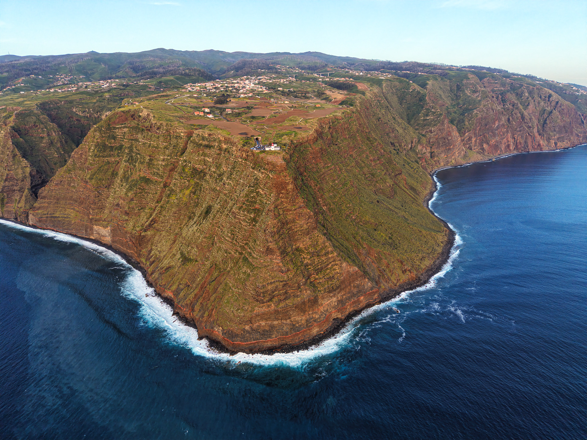 Widok od oceanu na klif i latarnię morską Farol da Ponta do Pargo, Madera